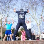 Group exercise session in a sunny Istanbul park led by a fitness coach outdoors.